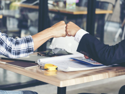 Zwei Menschen geben sich die Faust als Symbol für erfolgreiche Zusammenarbeit.